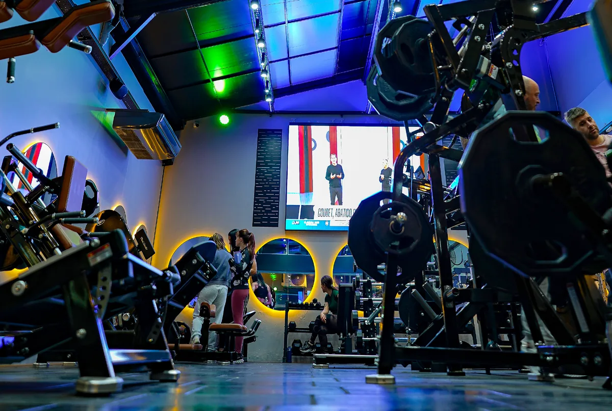 Sala de musculación de ONE GYM ELITE con pantalla gigante e iluminación LED